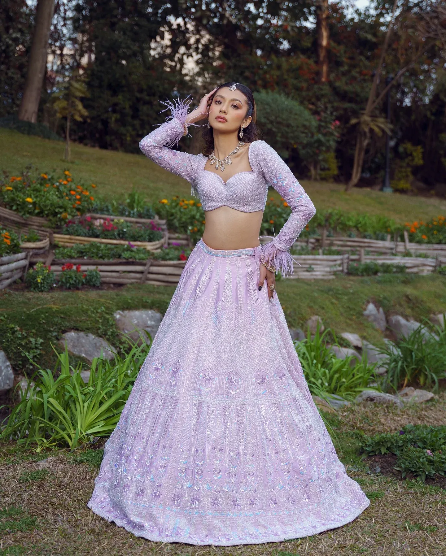 A lilac lehenga with scalloped bead work and a beaded bralette, photographed in a garden.