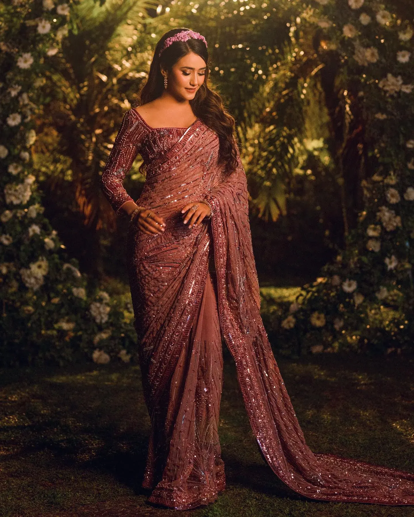 A rose saree in embroidered net with a beaded blouse, draped and photographed in a garden.